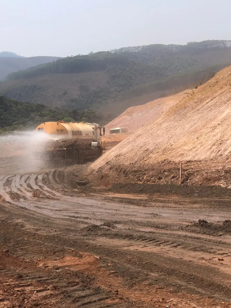 Caminhão pipa molhando cainho de serviço